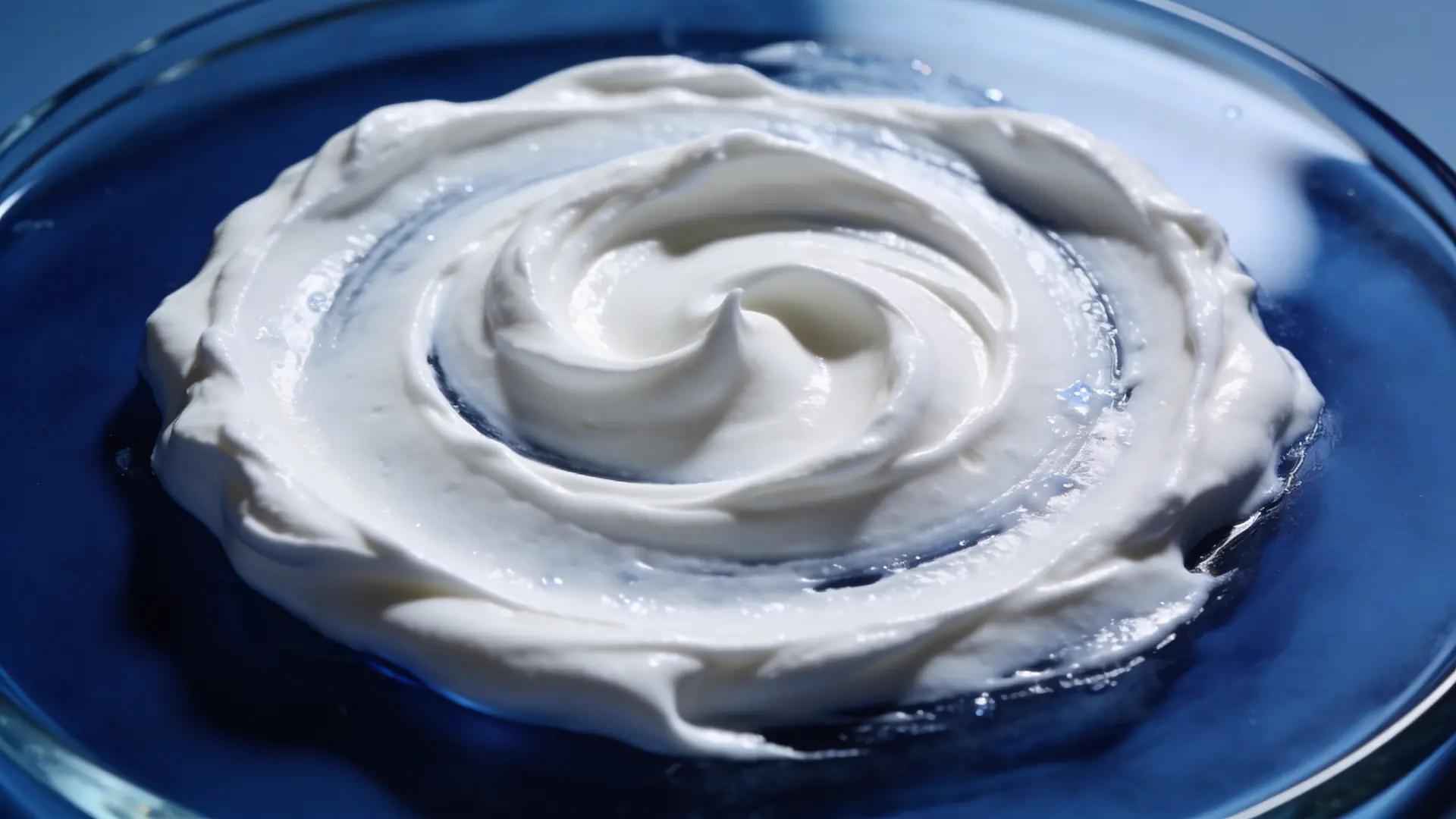 A swirl of white cream on blue glass