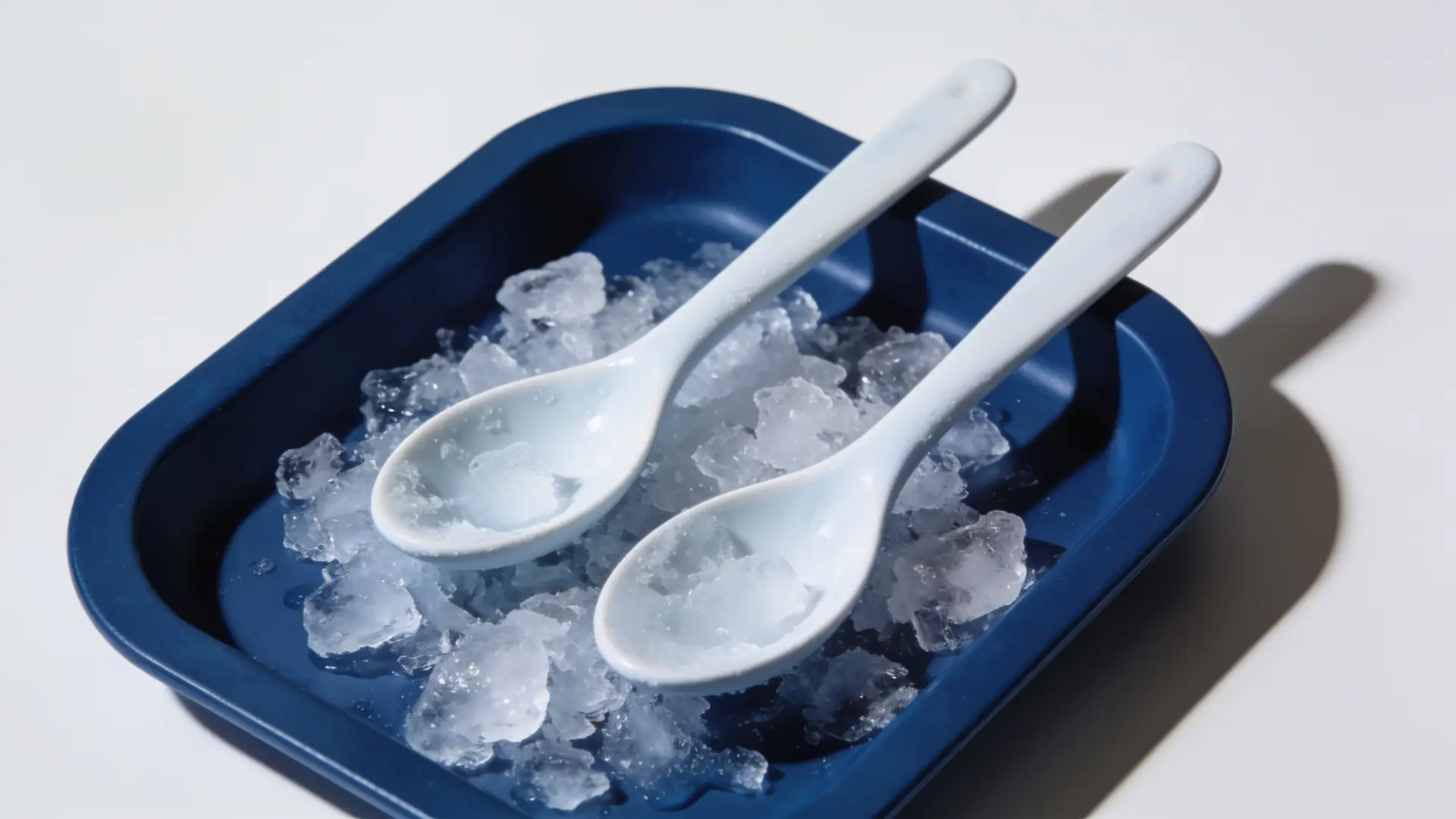 Two chilled porcelain spoons on crushed ice — illustrative image for dark eye circles