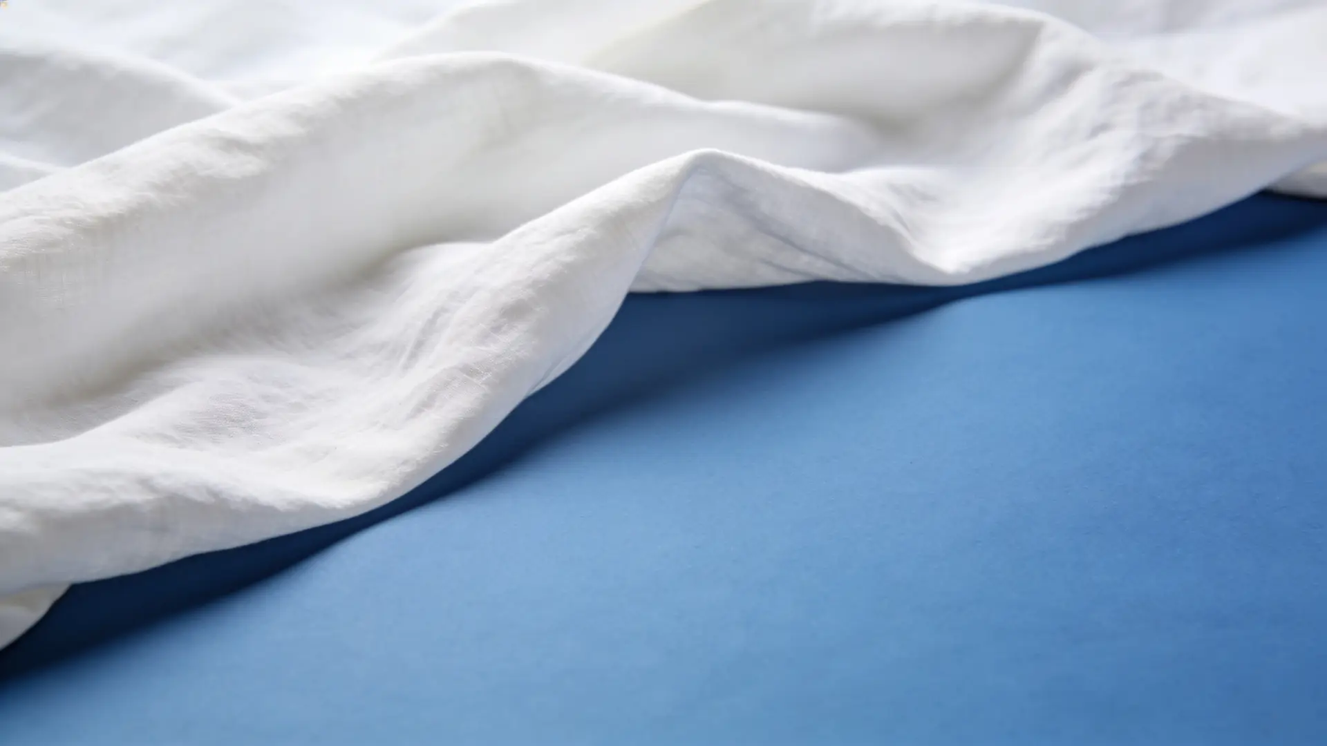 Soft white cotton draped over a blue surface — illustrative image for underarm whitening
